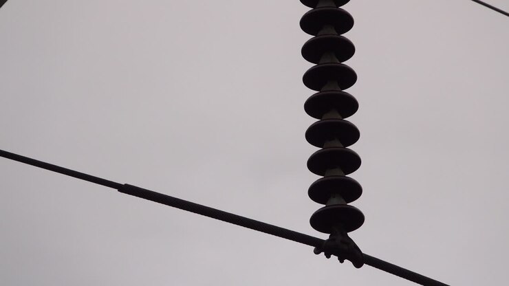 Close-up of electrical insulator on electrical transmission tower