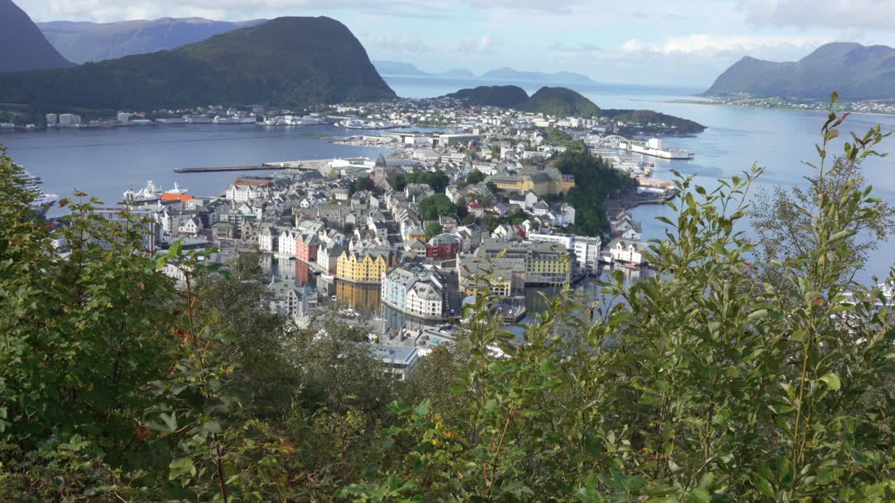 la arquitectura art nouveau de noruega se refleja en el canal de brosundet entre las islas de nørvøy y aspøy en verano con cielos despejados y montañas en el fondo, akesund, noruega, estableciendo la toma