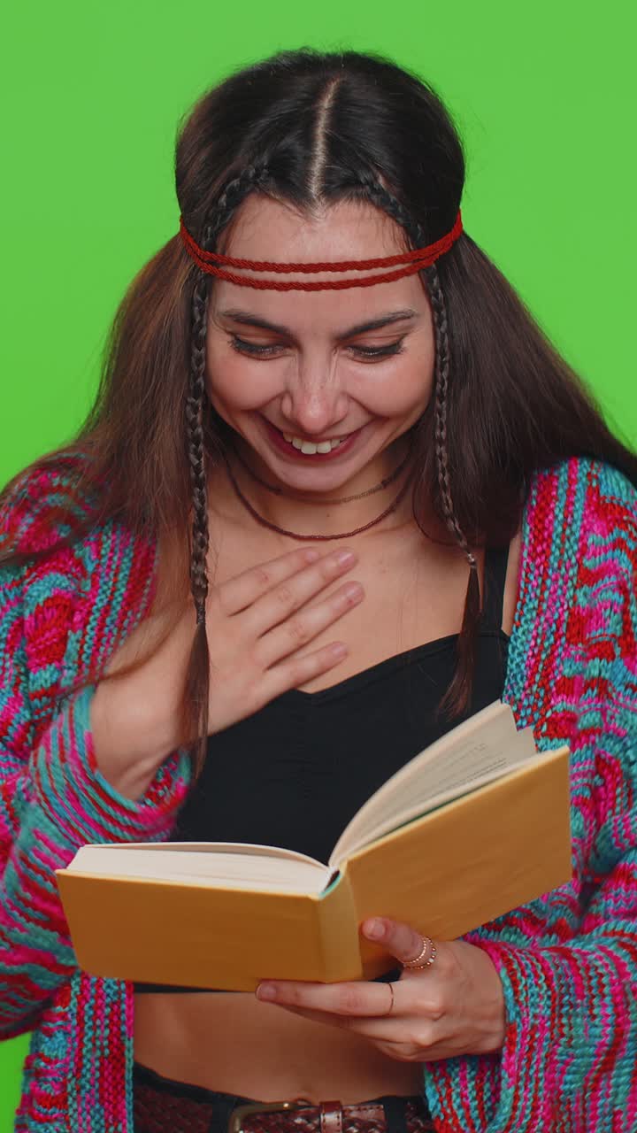 Giovane donna hippie che legge un divertente e interessante libro di fiabe, ridendo, come passatempo.