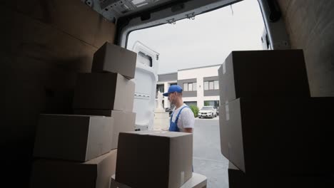 two young workers of removal company are loading boxes and furniture into a minibus