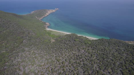 Paisaje-De-Exuberante-Colina-Costera-Verde-Y-Mar-Turquesa-En-Clam-Bay-En-La-Isla-Great-Keppel