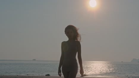 woman enjoying a sunset stroll on the beach