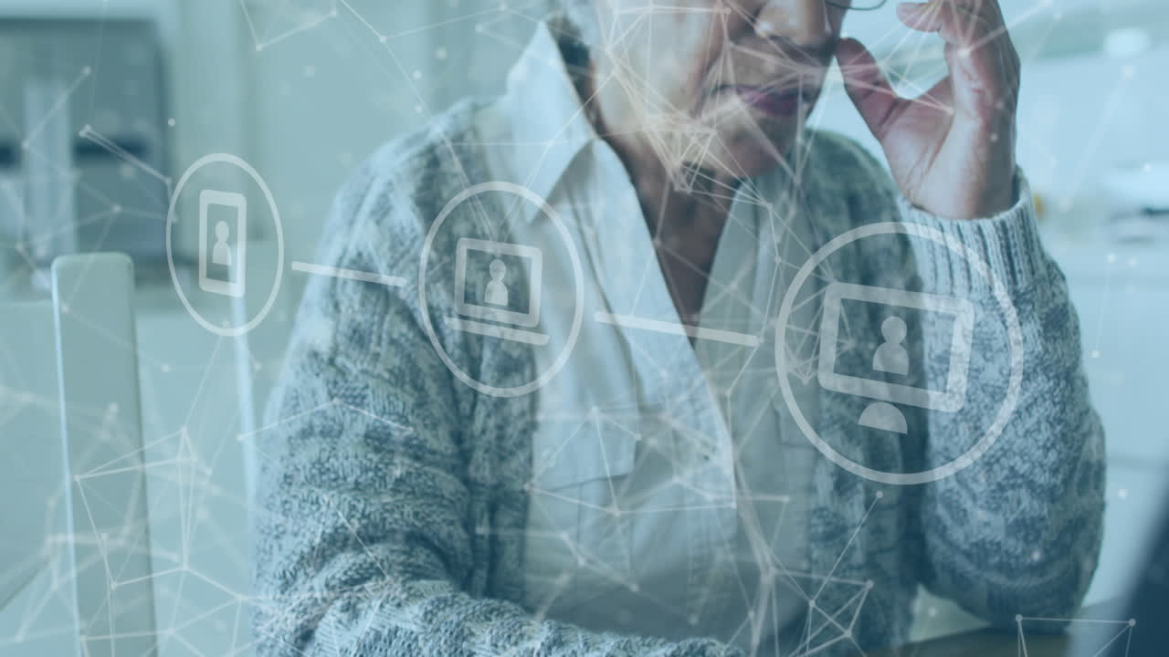 animación de m sobre una feliz mujer mayor afroamericana que usa una computadora portátil en casa