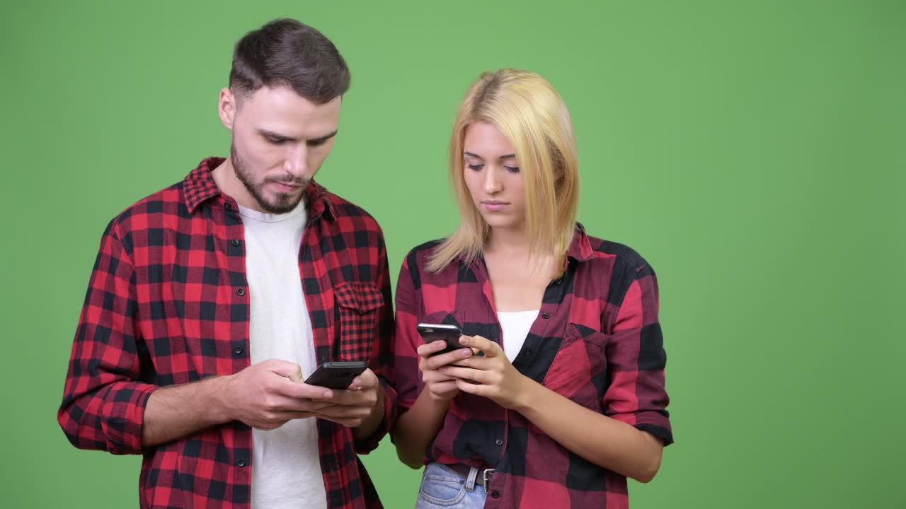 una pareja joven usando el teléfono juntos.