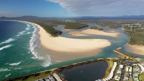 Gran-Tiro-De-Dron-Que-Gira-Lentamente-De-La-Playa-De-Crianza,-El-Río-Nambucca-Y-El-Océano-En-Nambucca-Heads-Nueva-Gales-Del-Sur-Australia