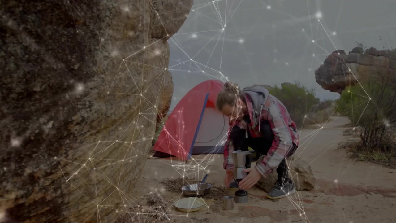 Mandlig camper ankommer til campingplads og pakker madlavningsudstyr ud ved siden af telt for at brygge kaffe på komfur