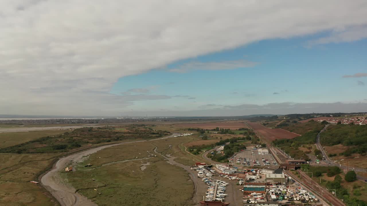 vuelo de retorno aéreo sobre el antiguo pueblo pesquero de leigh leigh en el mar mostrando arroyos, marismas, tejados de astilleros, barcos amarrados y negocios en el muelle 50 fps mavic 2 pro