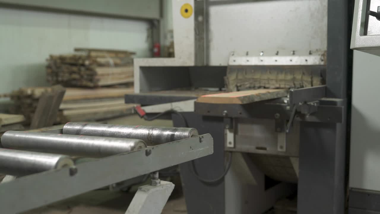 un primer plano de una pieza de madera que se mueve en una cinta transportadora industrial