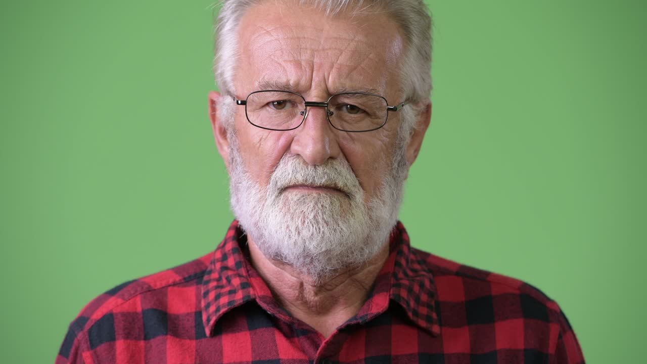 hombre de barba viejo y guapo contra un fondo verde.