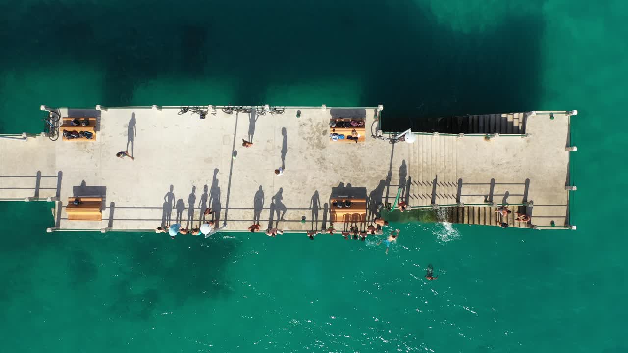 imagen fija tomada por un dron de un muelle con gente en porto santo, madeira