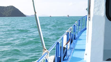 a serene boat ride in phuket, thailand, showcasing vibrant blue waters and distant islands under clear skies