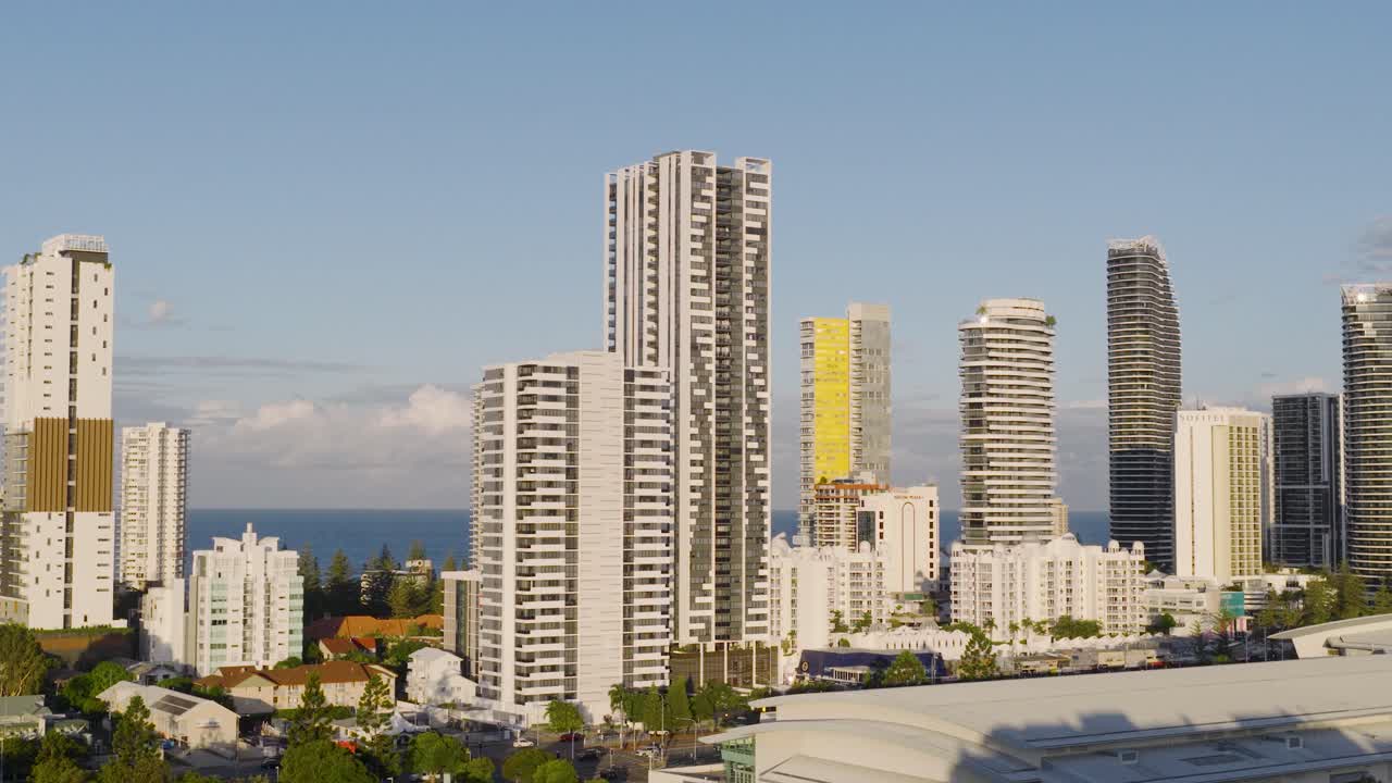 Drone footage captures Gold Coast's skyline with high-rise buildings and ocean backdrop during golden hour