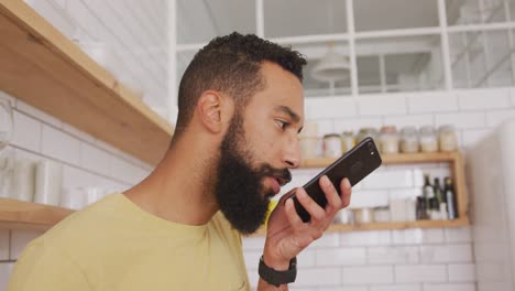 hombre hablando por teléfono inteligente en casa