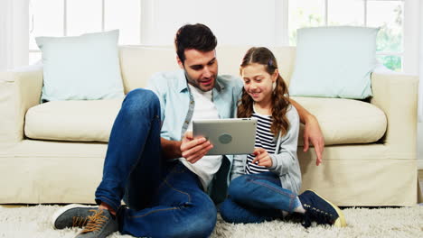 padre e hija usando tableta digital en la sala de estar
