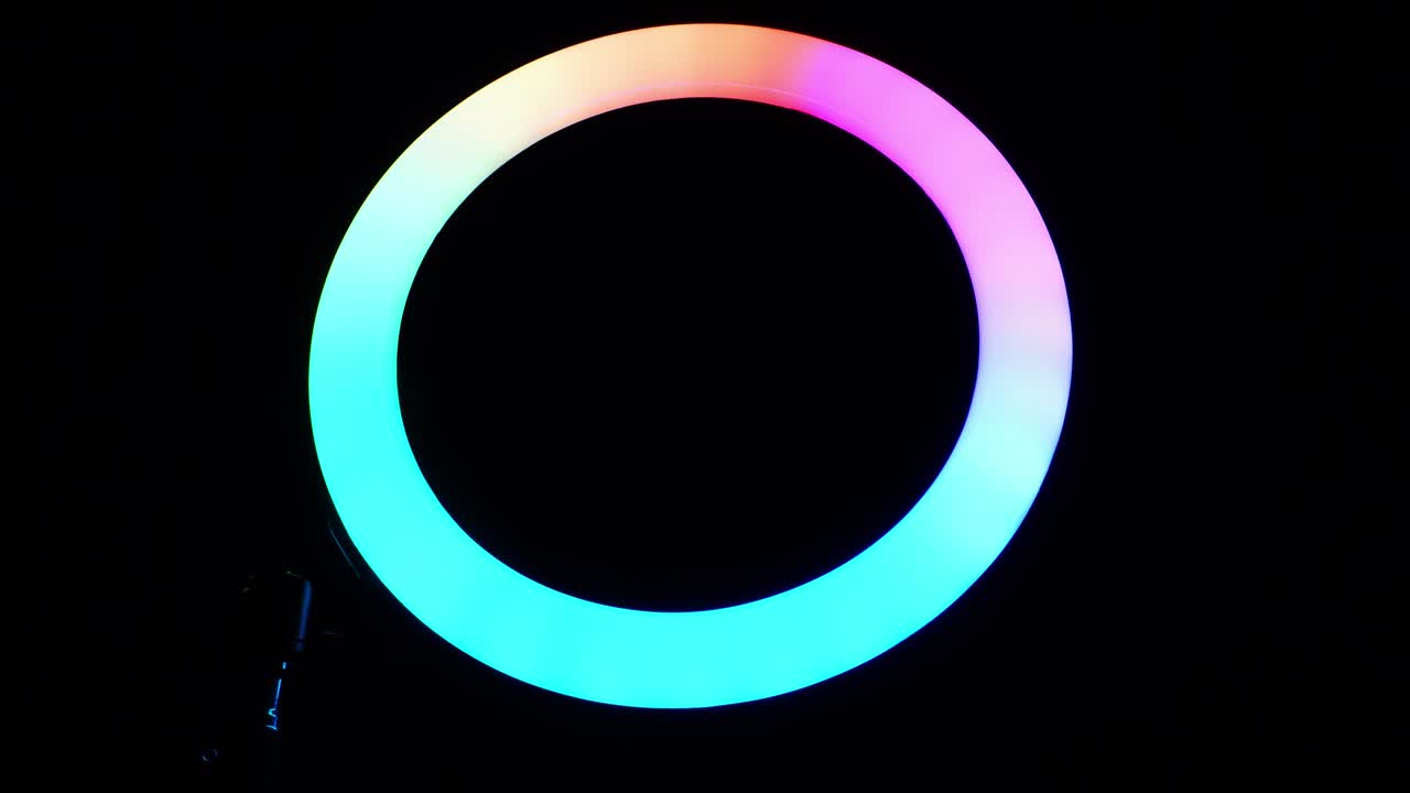 lámpara rgb de anillo luminoso. luz multicolor en una habitación oscura, primer plano.