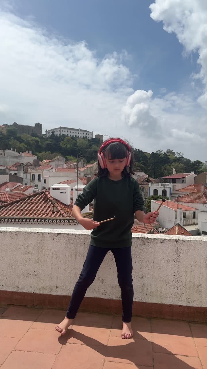 Young Girl Dancing on a Rooftop with Headphones