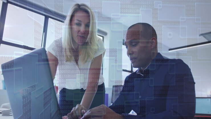 Business professionals working on laptop with digital binary code overlay animation