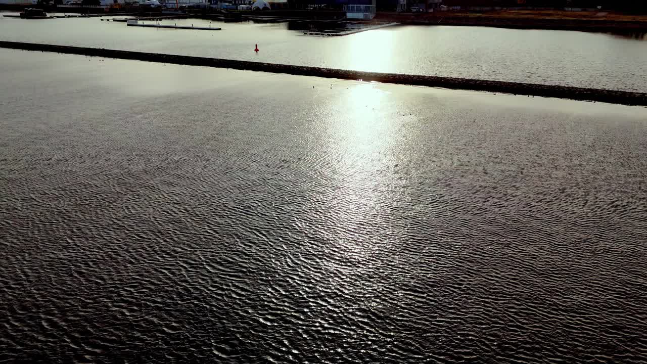superficie brillante del agua del mar con reflejos del sol al atardecer - fotografía de un avión no tripulado