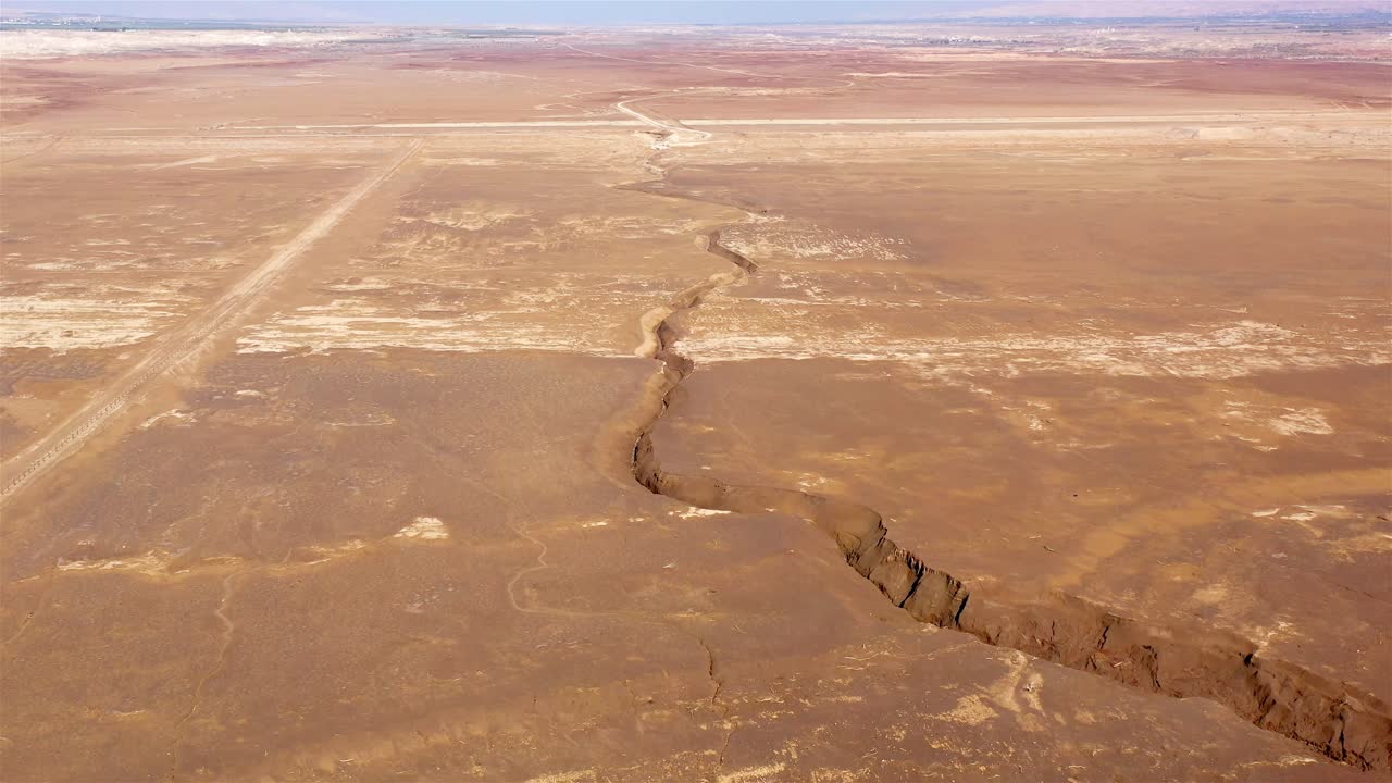 Deep Earth Crack in Expansive Arid Desert Landscape from Above