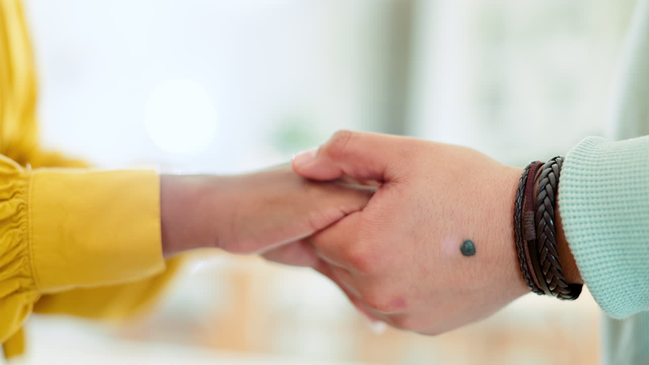 pareja, de cerca y tomados de la mano por amor