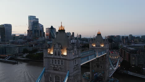 Slide-and-pan-footage-of-Tower-Bridge-top-walkway-in-evening.-Modern-downtown-skyscrapers-in-background.-Parallax-effect.-London,-UK