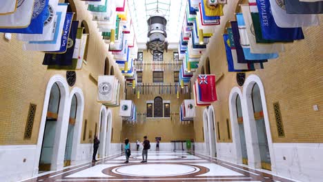 impressive interior with numerous flags hanging in a grand hall