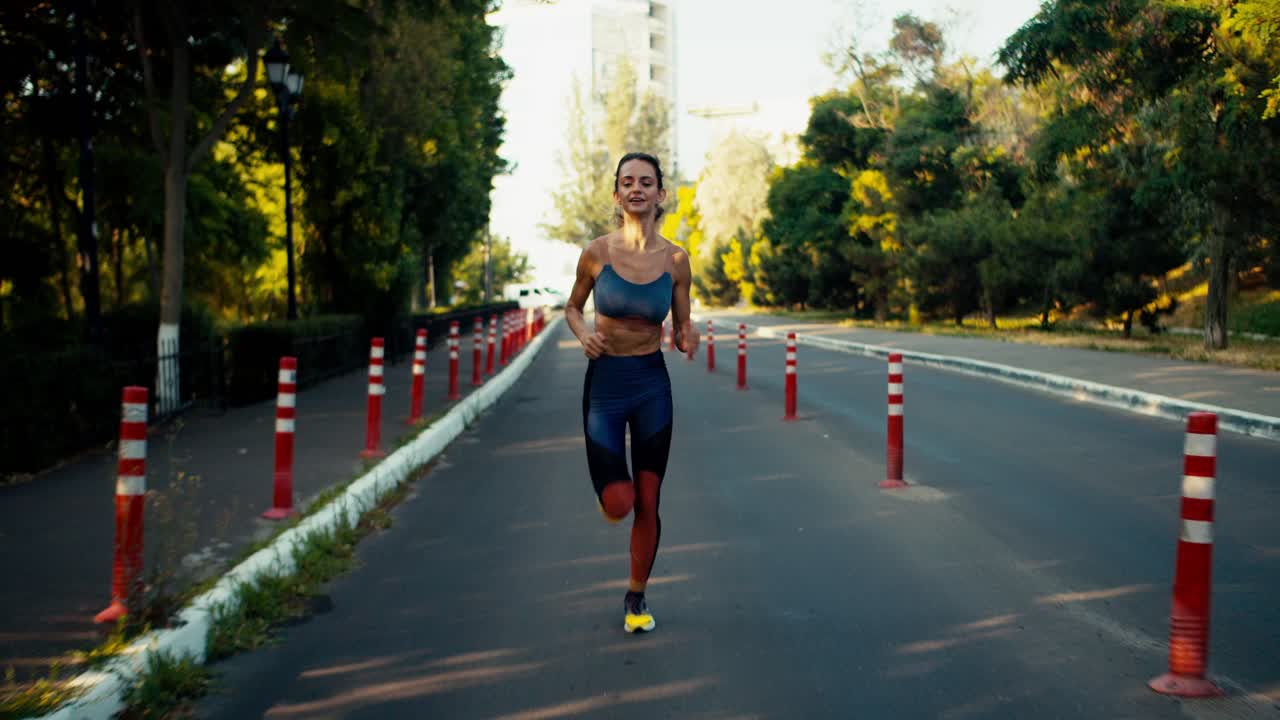 una chica deportiva en un uniforme deportivo de verano corre a lo largo de las señales rojas en la carretera. deporte de jogging por la mañana
