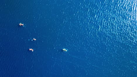 overhead view truck right of people in kayaks on the laguna del inca, in the chilean andes near the border between chile and argentina