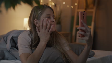 woman taking a selfie in bed at night