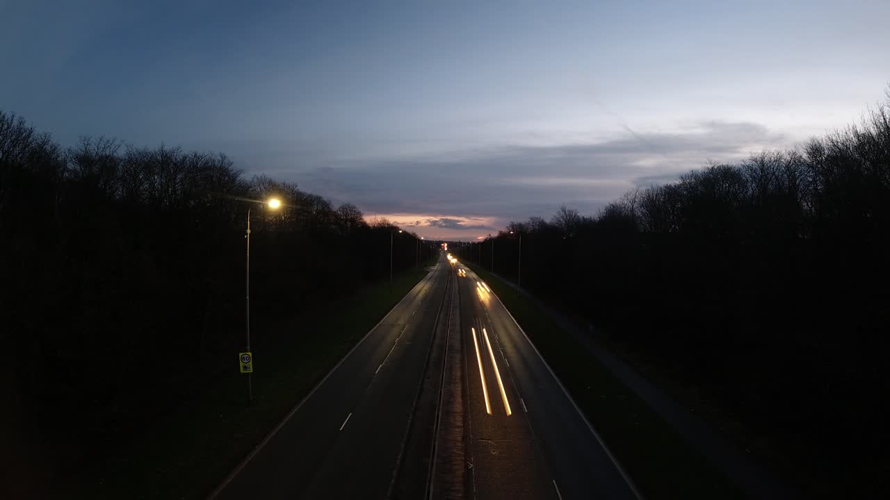 largas luces de racha de tráfico de carretera en el horizonte lejano del amanecer