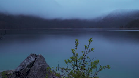 low misty cloud over lake eibsee and zugspitze mountain landscape in early morning light