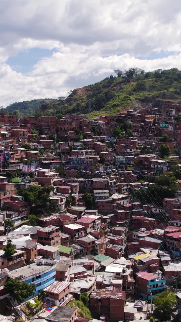 Vibrant residential hillside neighborhood showcasing architecture, rooftops, and dramatic urban scenery. Aerial, Vertical Video