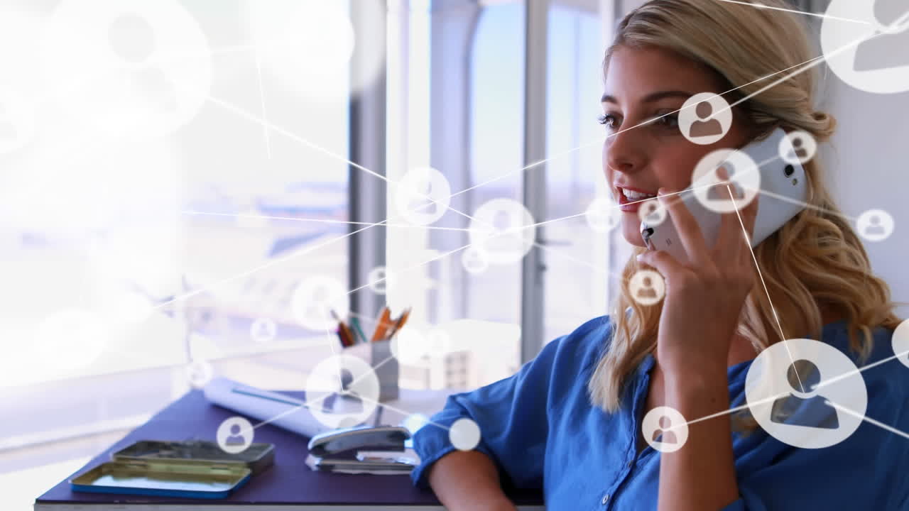 Animation of network of connections with icons over caucasian businesswoman talking on smartphone