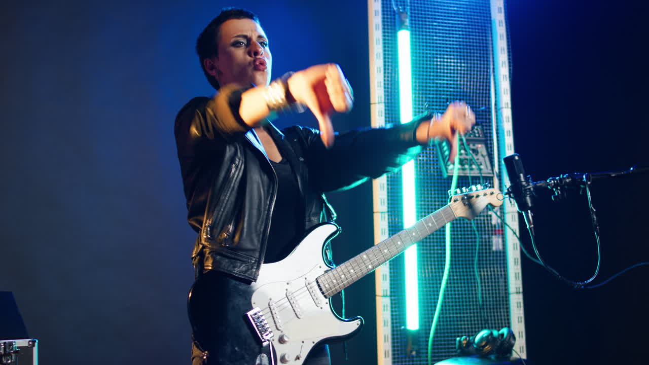 Woman performing with a guitar on stage