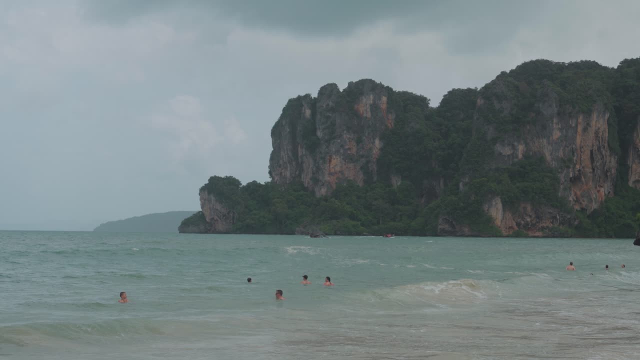 Tropical beach with people swimming