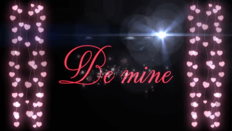 be mine text animation over hanging pink heart lights on black background