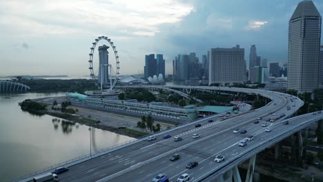 Disparo-De-Un-Dron-Volando-Sobre-El-Puente-Ecp-Hacia-El-Paseo-Marítimo-Y-El-Ojo-Del-Volante-De-Singapur,-Seguimiento-Del-área-Del-Paddock-De-Fórmula-1