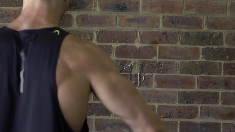 Muscly-man-in-home-gym-exercising-shot-from-back-lateral-shoulder-raise-cable-machine