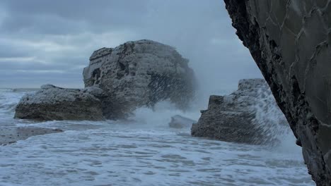 big stormy waves breaking against abandoned seaside fortification building ruins at karosta northern forts in liepaja, slow motion wide shot