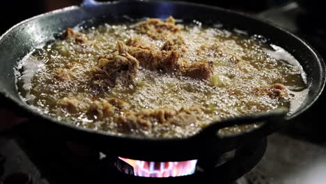 close-up of sizzling hot deep fried chicken cooking in a wok