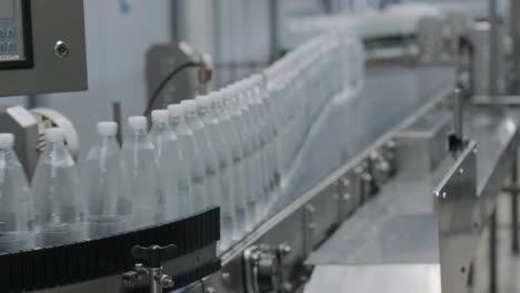 cinta transportadora con botellas de agua potable en una planta de bebidas moderna