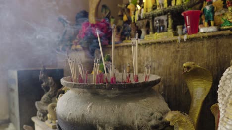 räucherstäbchen brennen in einem topf im thailändischen buddhistischen tempel