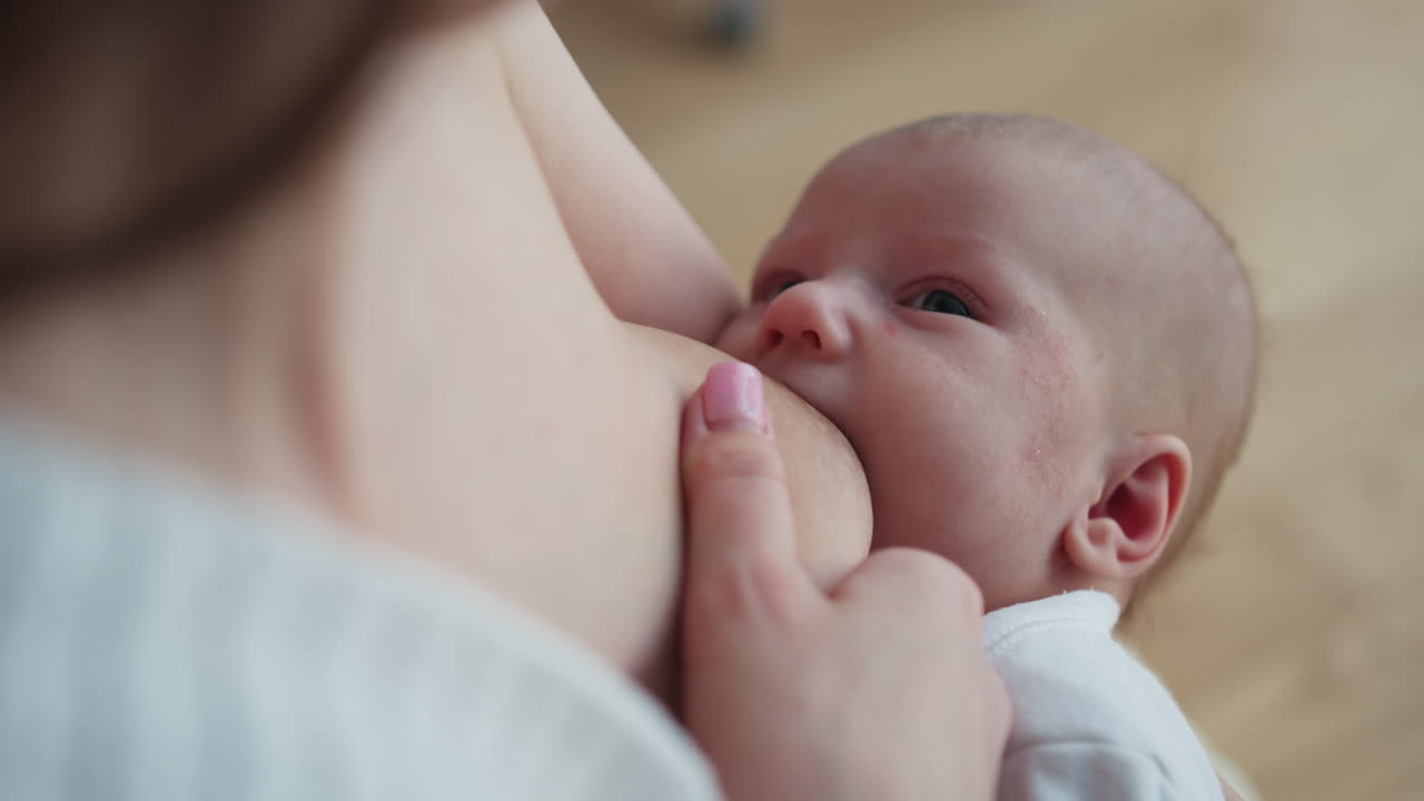 Primer plano de madre amamantando a bebé recién nacido, mostrando el tierno vínculo, amor, alegría y la maternidad en familia