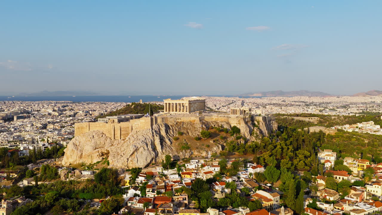 Drone melakukan pengambilan gambar panorama lambat di atas Acropolis dan Parthenon di Athena saat matahari terbit, dengan cahaya keemasan hangat menerangi bangunan kuno