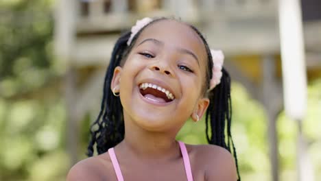 portrait of happy african american girl smiling in garden