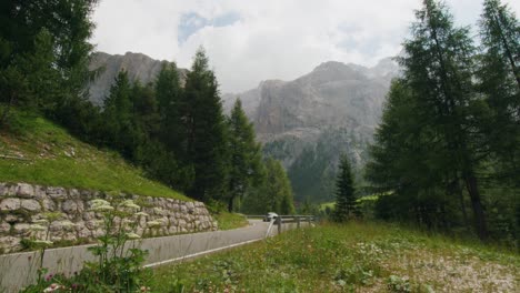 silver sport car driving on a twisty mountain road in the italian dolomites alps