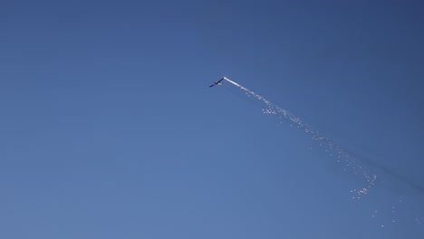 pyrotechnical aircraft releasing fireworks from one wing during its display