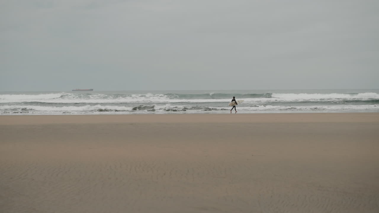 Surfer on a cloudy beach