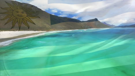 composición digital de la bandera uruguaya ondeando contra la vista aérea de las olas en el mar