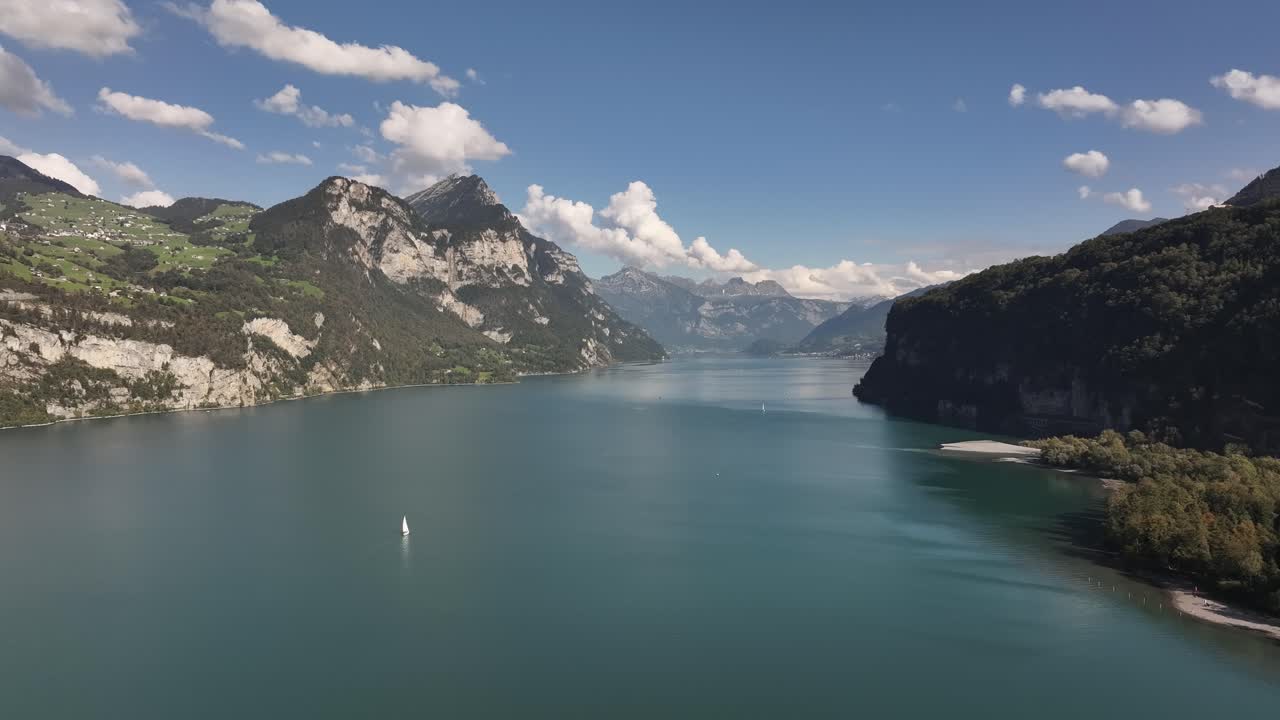 Aerial view of the calm, serene waters of Lake Walensee, nestled between Wessen and Walenstadt in Switzerland. Peaceful natural beauty with reflections and tranquil surroundings.